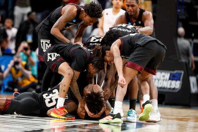 Texas A&M players swarm and celebrate Andersson Garcia (11) after he made a 3-pointer that sent the game into overtime during the second round game between Texas A&M and the University of Houston in the 2024 NCAA Tournament at FedExForum in Memphis, Tenn., on Sunday, March 24, 2024.
