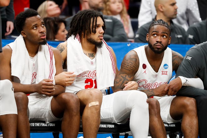 Houston's L.J. Cryer (4), Emanuel Sharp (21) and Jamal Shead (1) lock arms and watch the game from the bench after all three players fouled out during the second round game between Texas A&M and the University of Houston in the 2024 NCAA Tournament at FedExForum in Memphis, Tenn., on Sunday, March 24, 2024.