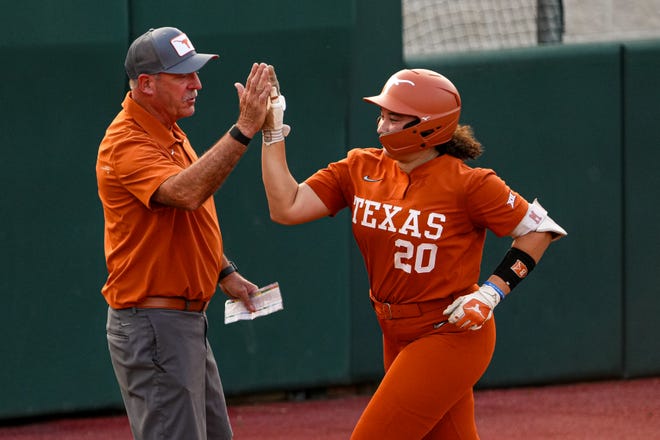 Texas Longhorns infielder Katie Stewart (20) high-fives head coach Mike White after a home run hit during the game against Iowa State at Red and Charline McCombs Field on Friday, April 26, 2024 in Austin.